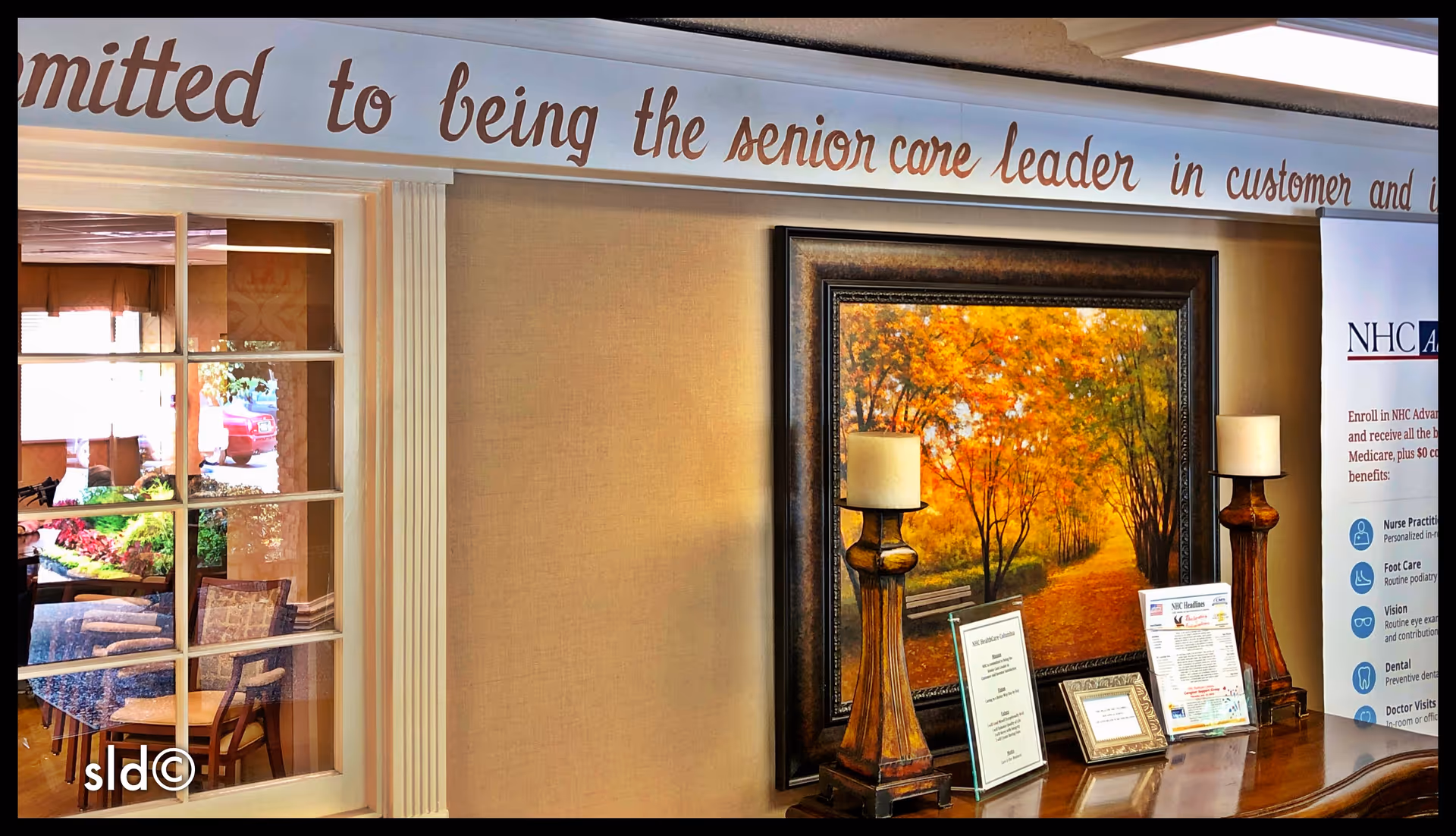 Lobby reception area with framed artwork, lamps, and informational displays.