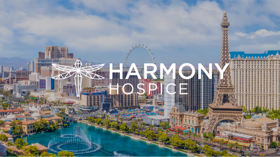 City skyline with a large Harmony Hospice overlay across a Las Vegas-style backdrop.