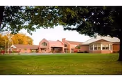 Front exterior view of Crawford County Care Center with brick facade, lawn, and trees.