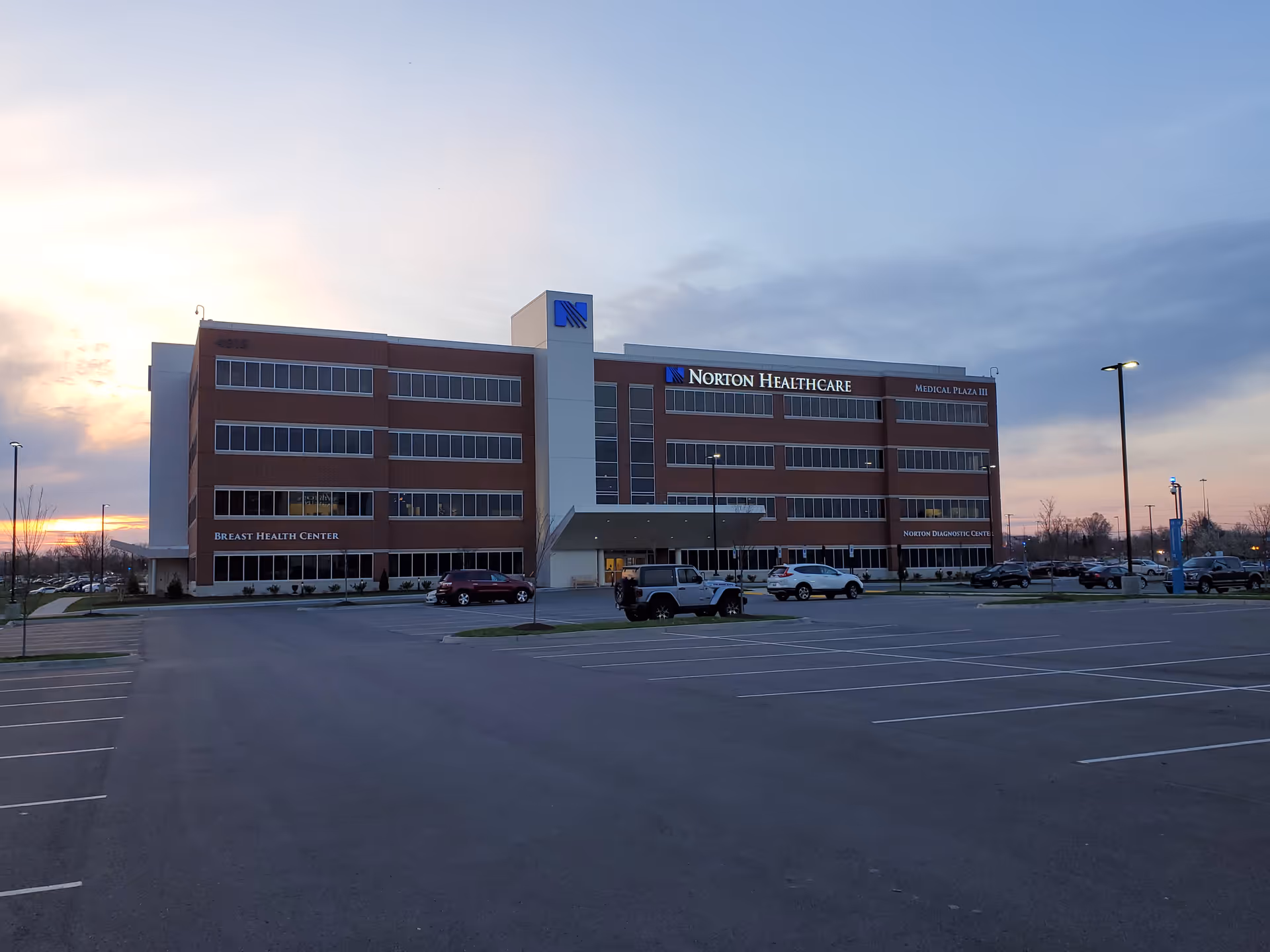 Exterior view of Norton Healthcare Medical Plaza III Brownsboro with a large parking lot.