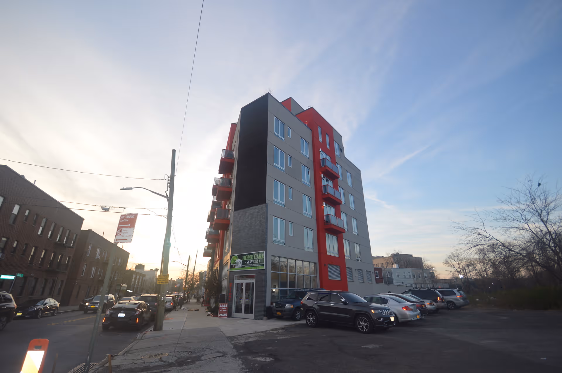 Exterior view of Eden Home Care Services building, a multi-story red-gray facility with parked cars.