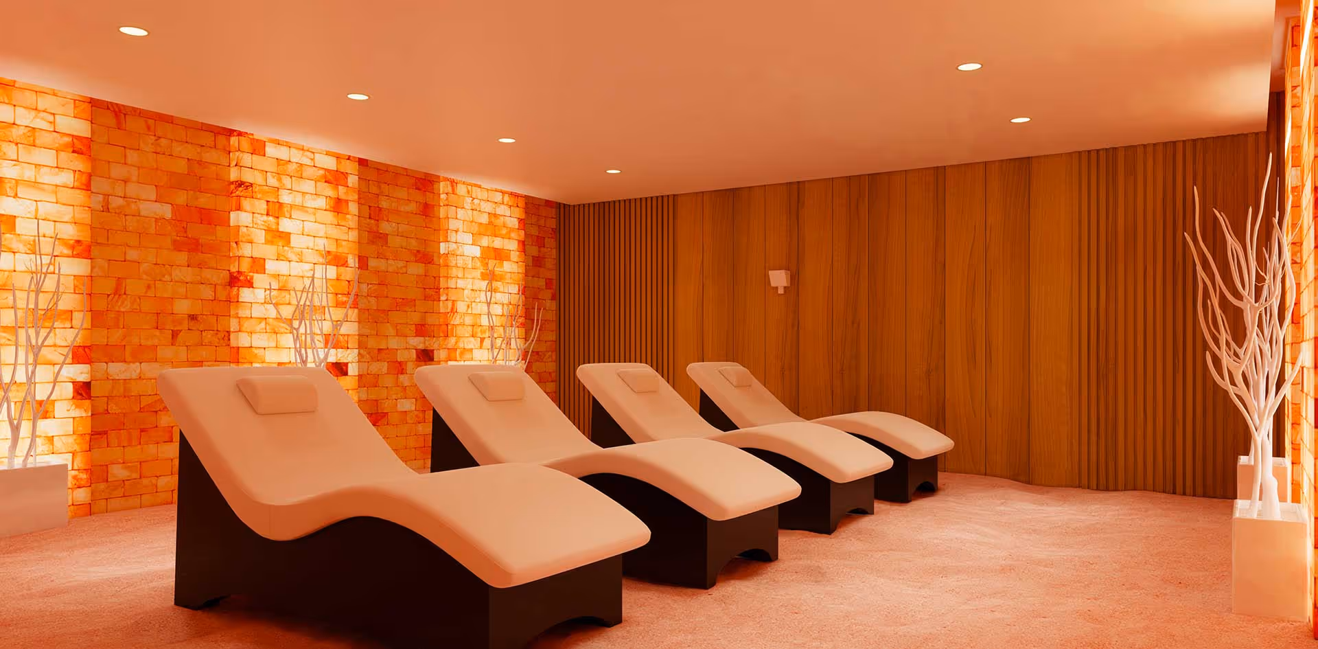 Warm interior with curved white lounge chairs in a spa relaxation room.