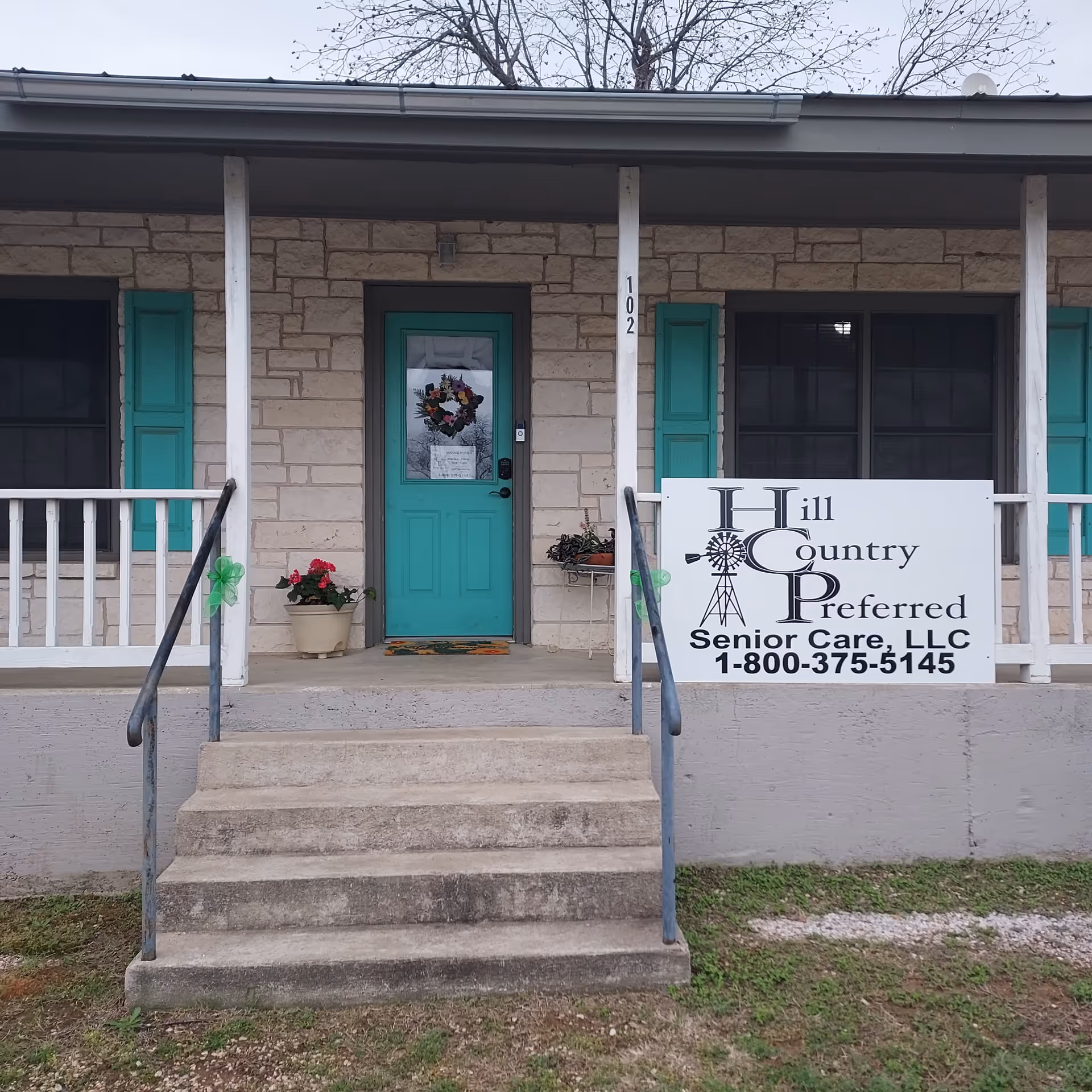 Front entrance of Hill Country Preferred Senior Care, Llano Branch, with teal door and sign.