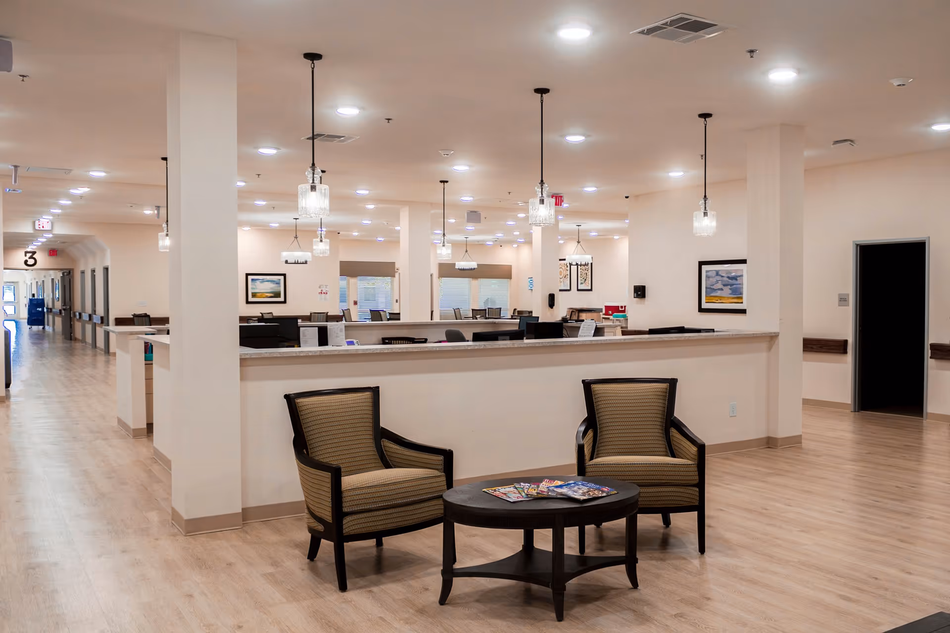 Spacious lobby interior with a reception counter and two armchairs around a coffee table.