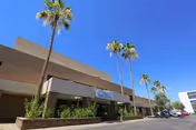 Exterior view of North Mountain Medical And Rehabilitation Center with palm trees and a parking lot.