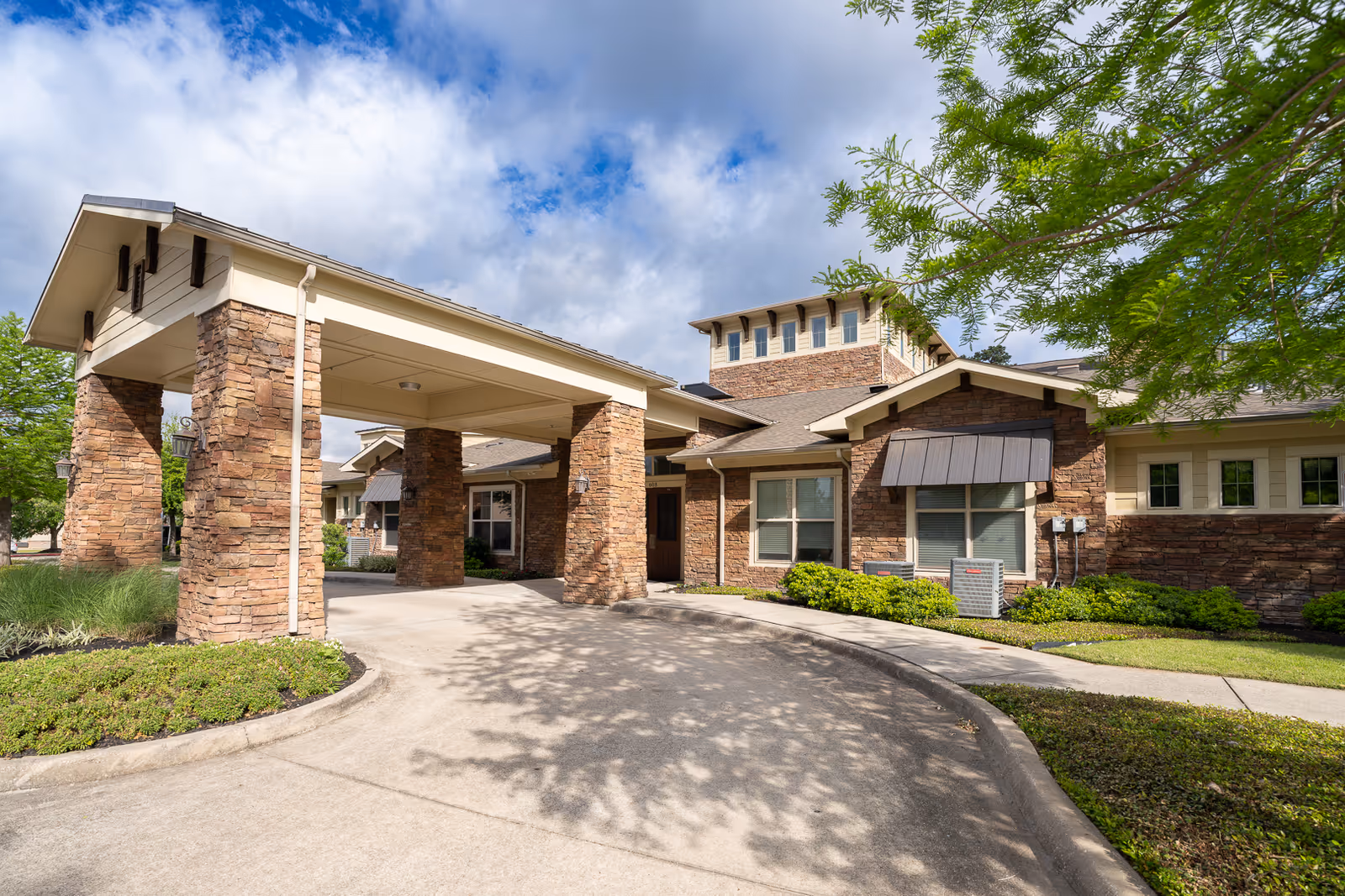 Exterior view of Bristol Park at Conroe entrance with stone pillars and driveway.
