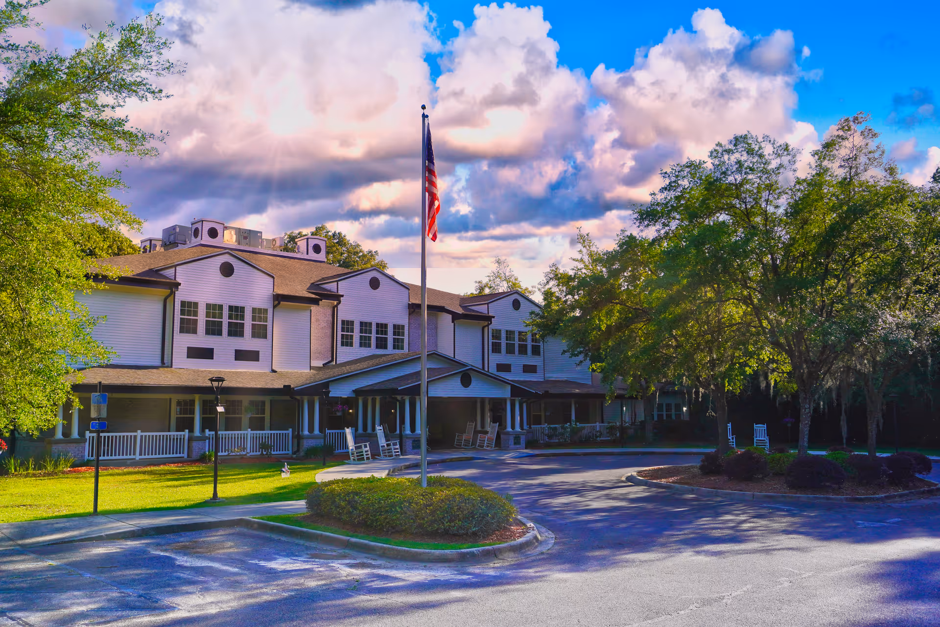 Sodalis Tallahassee Assisted Living exterior with flagpole, parking, and trees