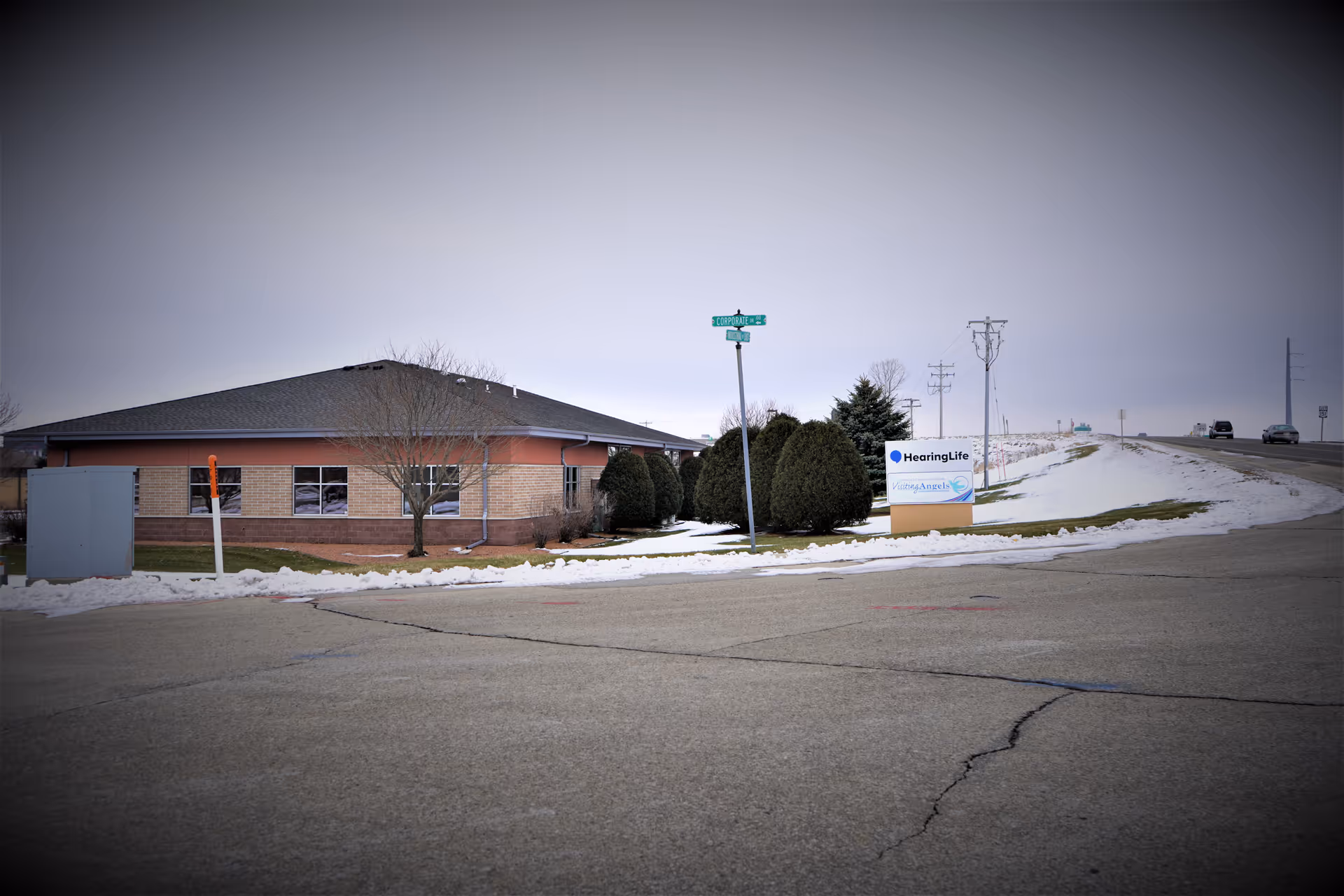 Exterior view of Visiting Angels senior home care facility with snow and a sign.