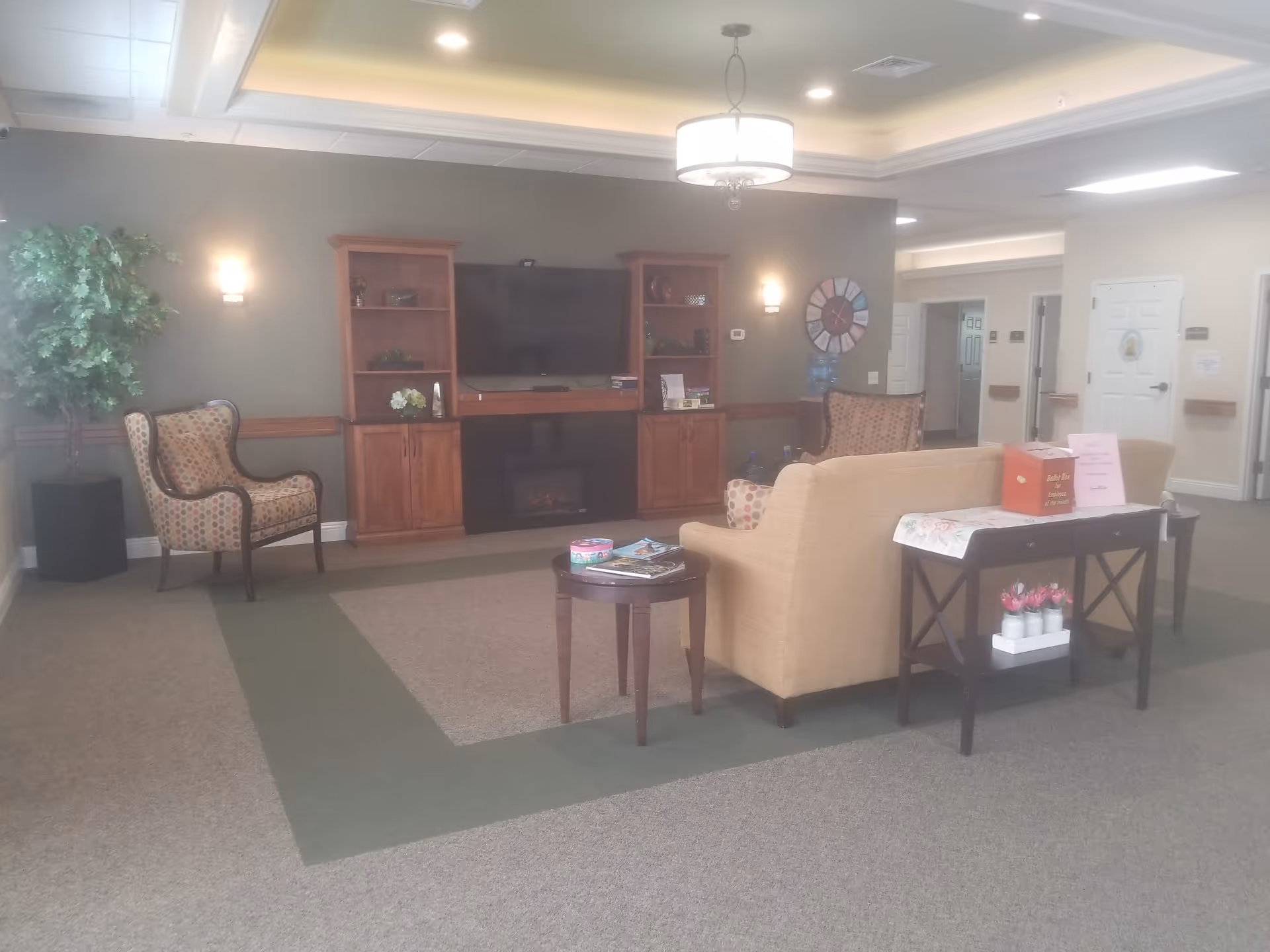 Common lounge area with sofa, chairs, TV, and coffee tables.