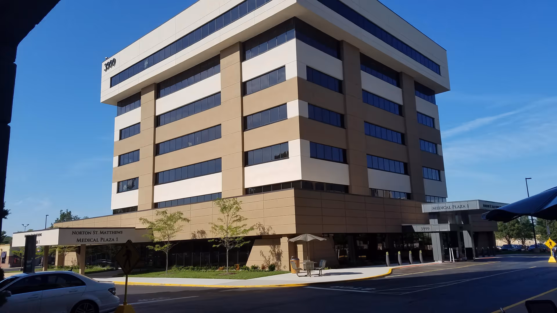 A tall, modern medical plaza building with beige and white exterior.
