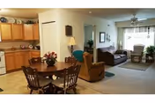 Interior living room with couch, chairs, coffee table, and dining area in Sunnycrest Retirement Village.
