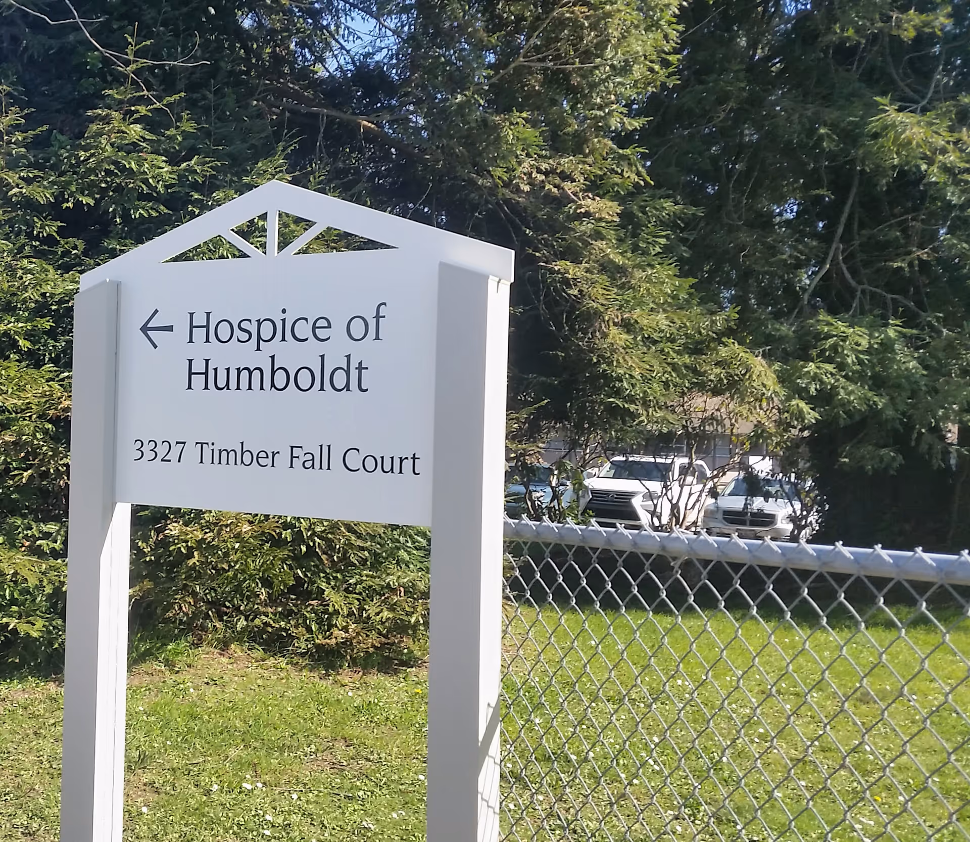 White Hospice of Humboldt sign beside a chain-link fence and trees.