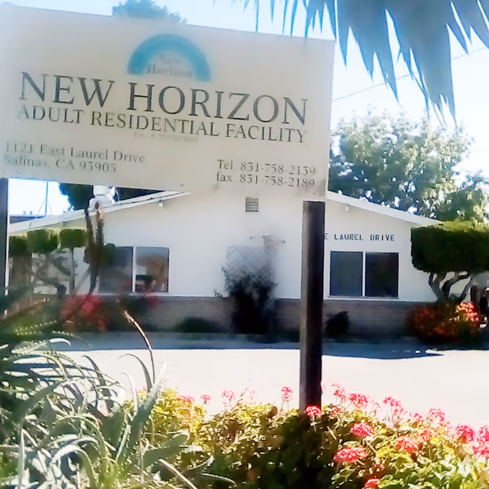 Front exterior of New Horizon Adult Residential Facility with a sign and landscaping.