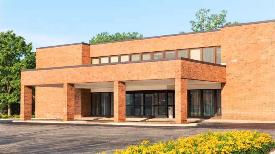 Red brick medical building with glass doors and a covered front entrance.