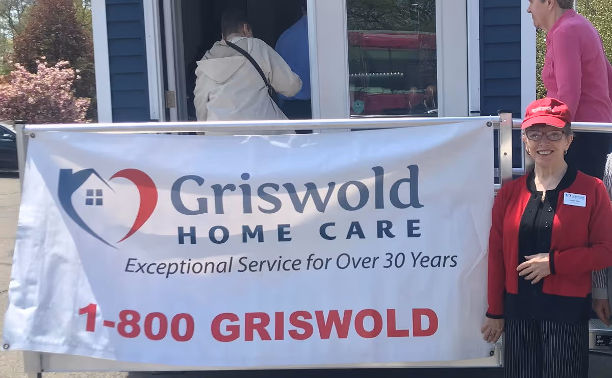 Exterior view of Griswold Home Care entrance with banner and staff member outside.