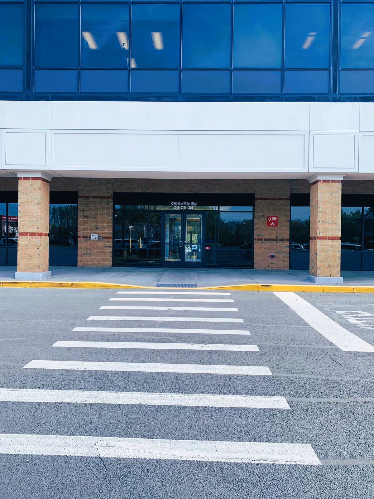 Front of Royal Home Care and Staffing LLC building with glass entrance and crosswalk
