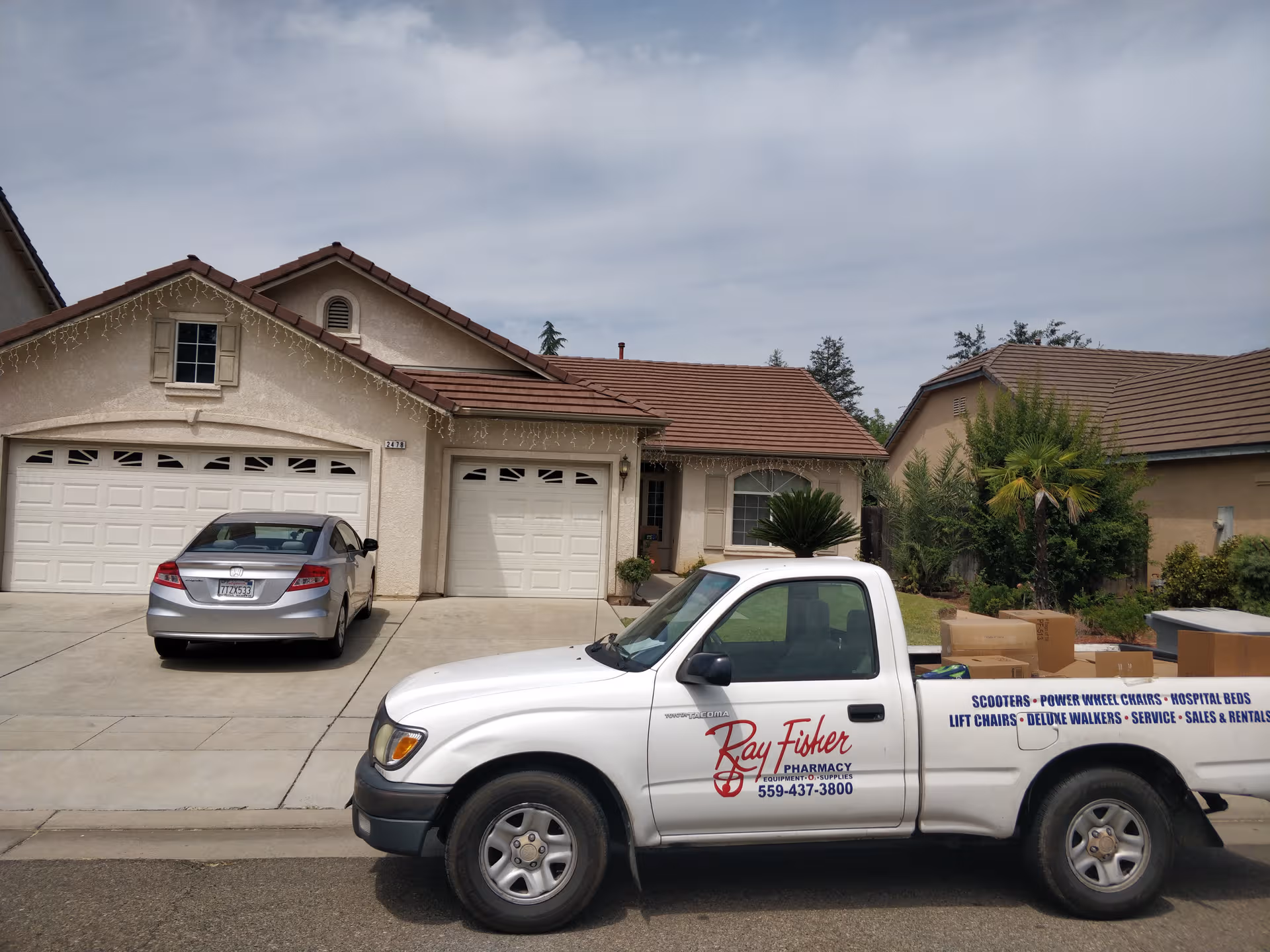 Residential building front with two garages and a branded pickup in driveway