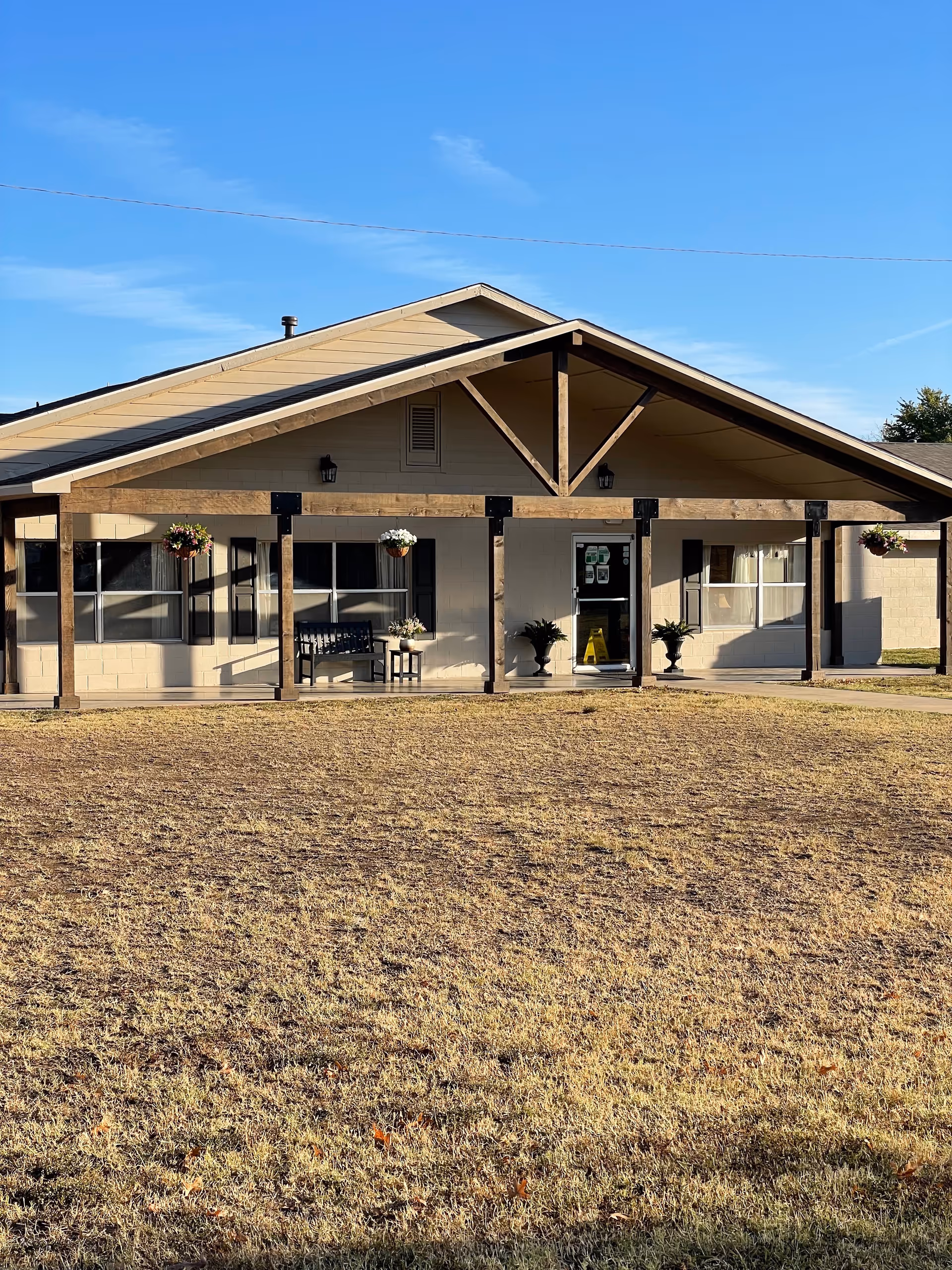 Front view of Oakridge Home facility with covered entrance and hanging plants.