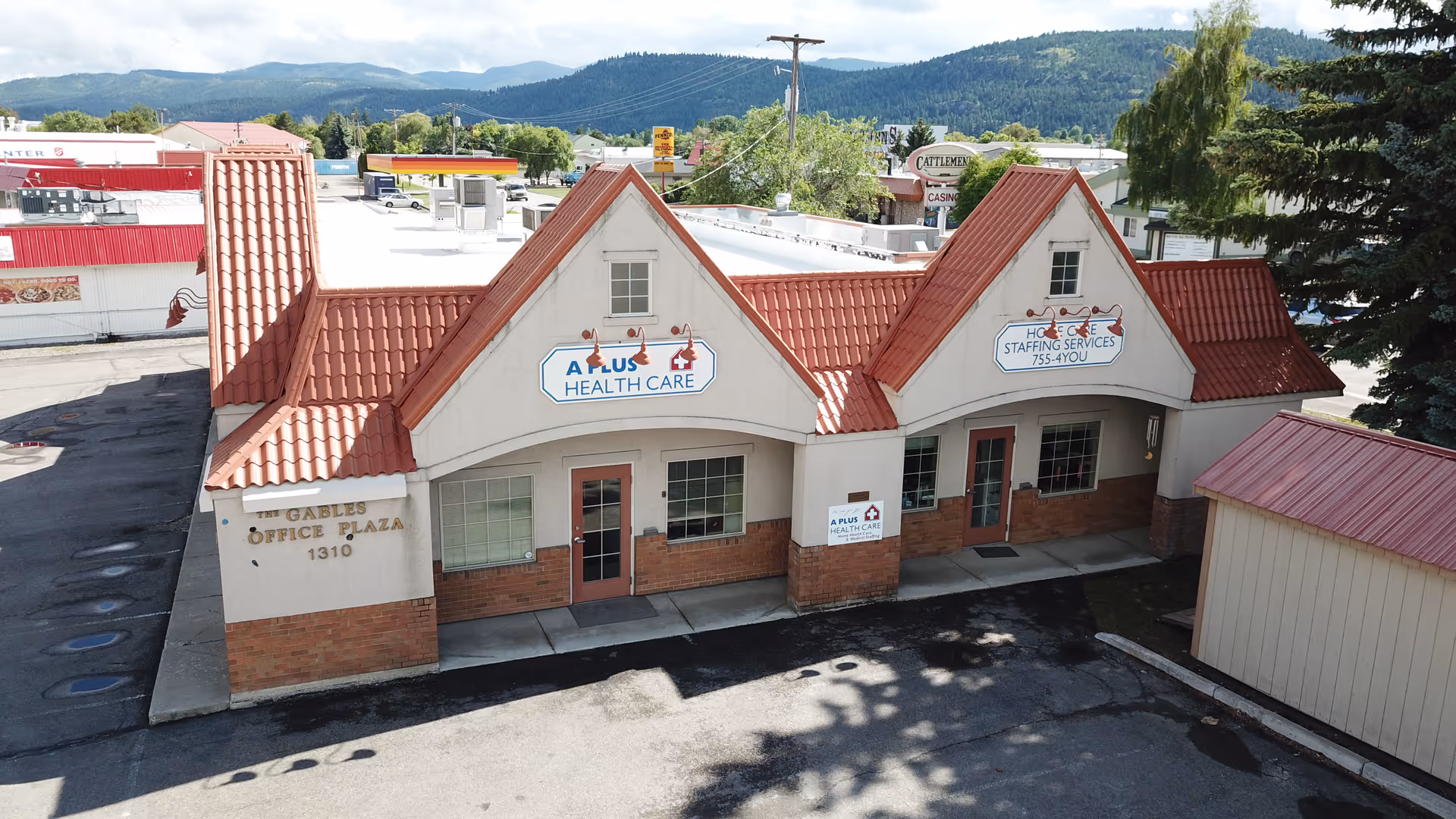 Exterior view of A Plus Health Care building with red-tiled roof and signage.