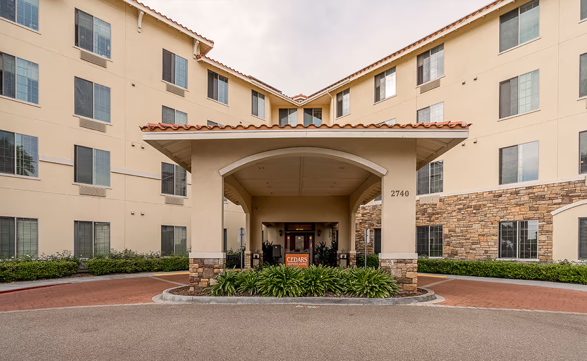 Exterior of Paradise Village senior living building with a covered entrance and landscaping.