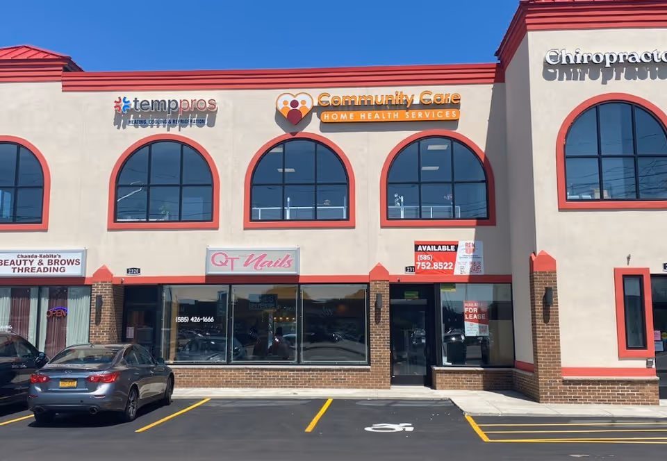 Facade of a strip mall featuring Community Care Health Services signage and arched windows.