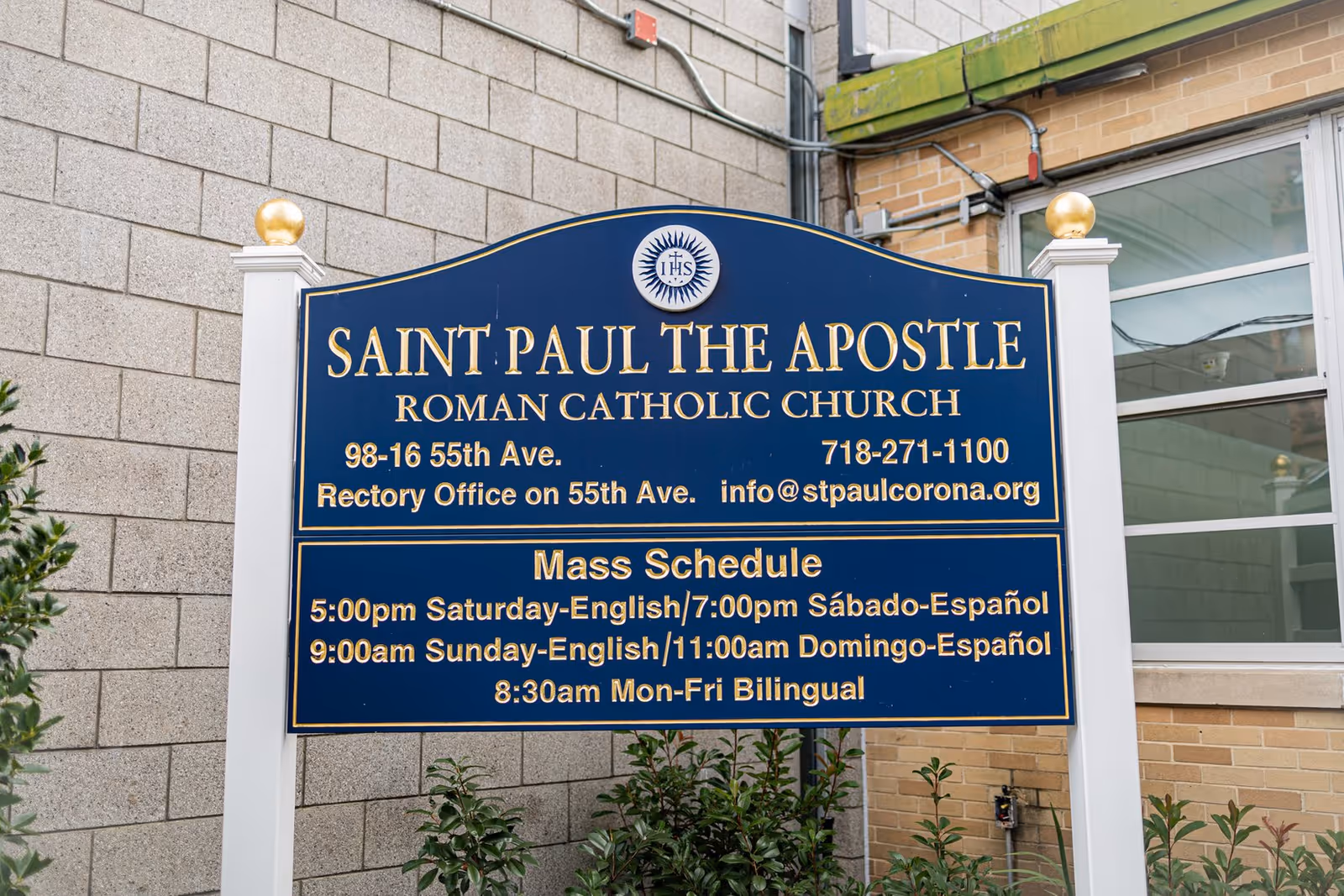 Blue church sign on brick exterior reading Saint Paul the Apostle Roman Catholic Church