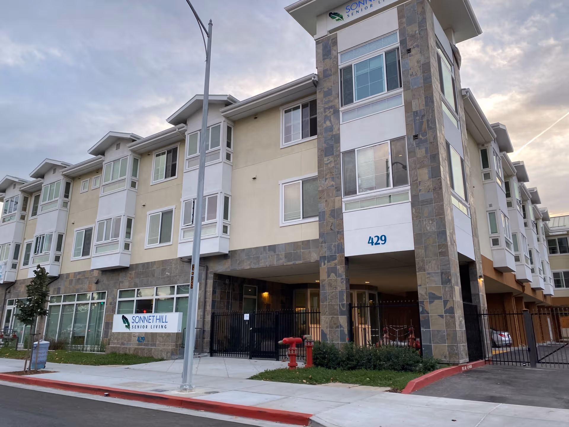 Exterior view of Sonnet Hill Senior Living building with gated entrance.