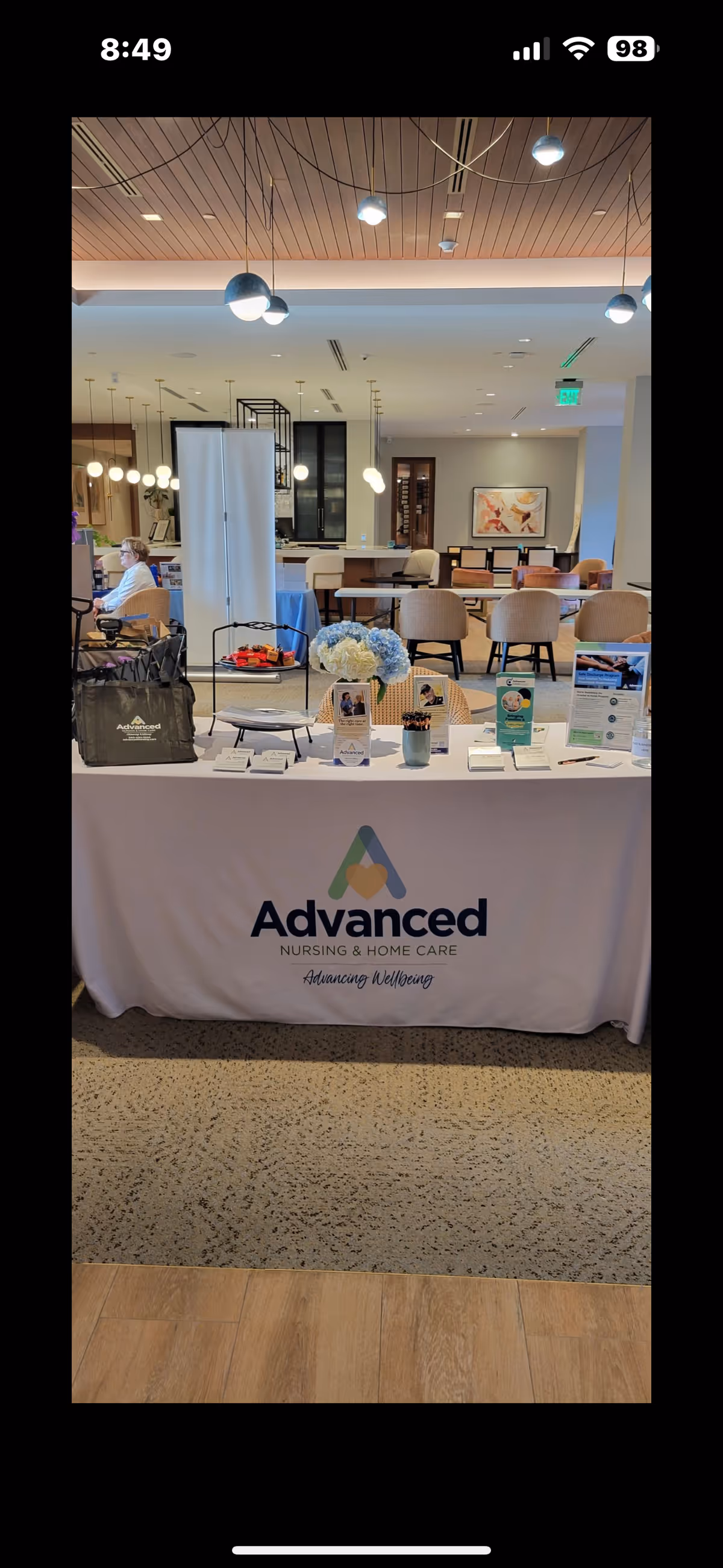 Lobby reception area with an Advanced Nursing & Home Care table and brochure displays.