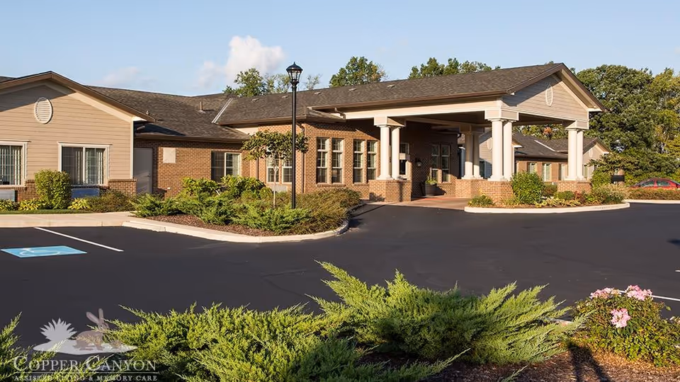 Exterior view of Copper Canyon senior living facility with entrance canopy and parking.