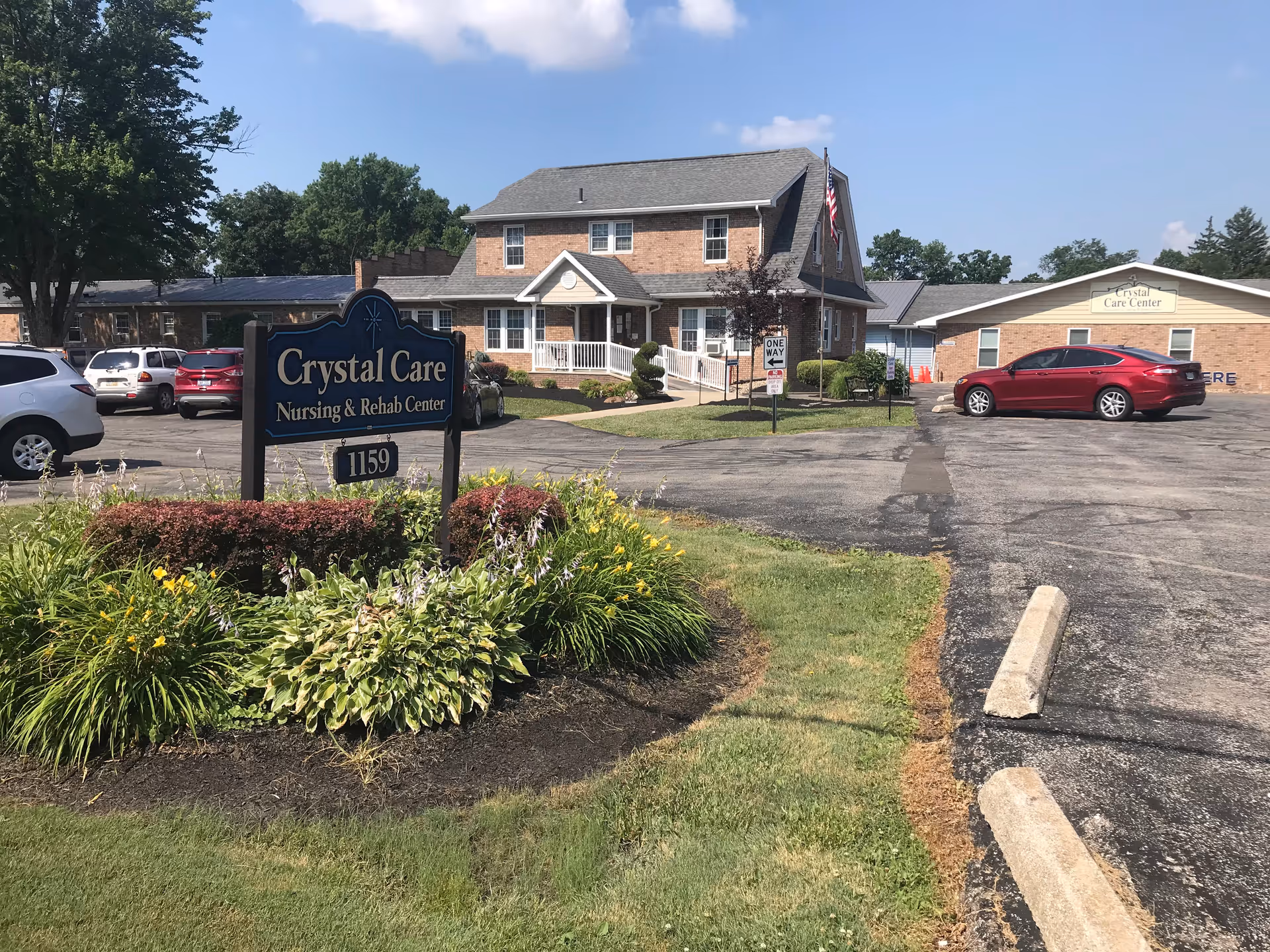 Exterior view of Crystal Care Centers of Mansfield with sign, parking, and landscaped entrance.