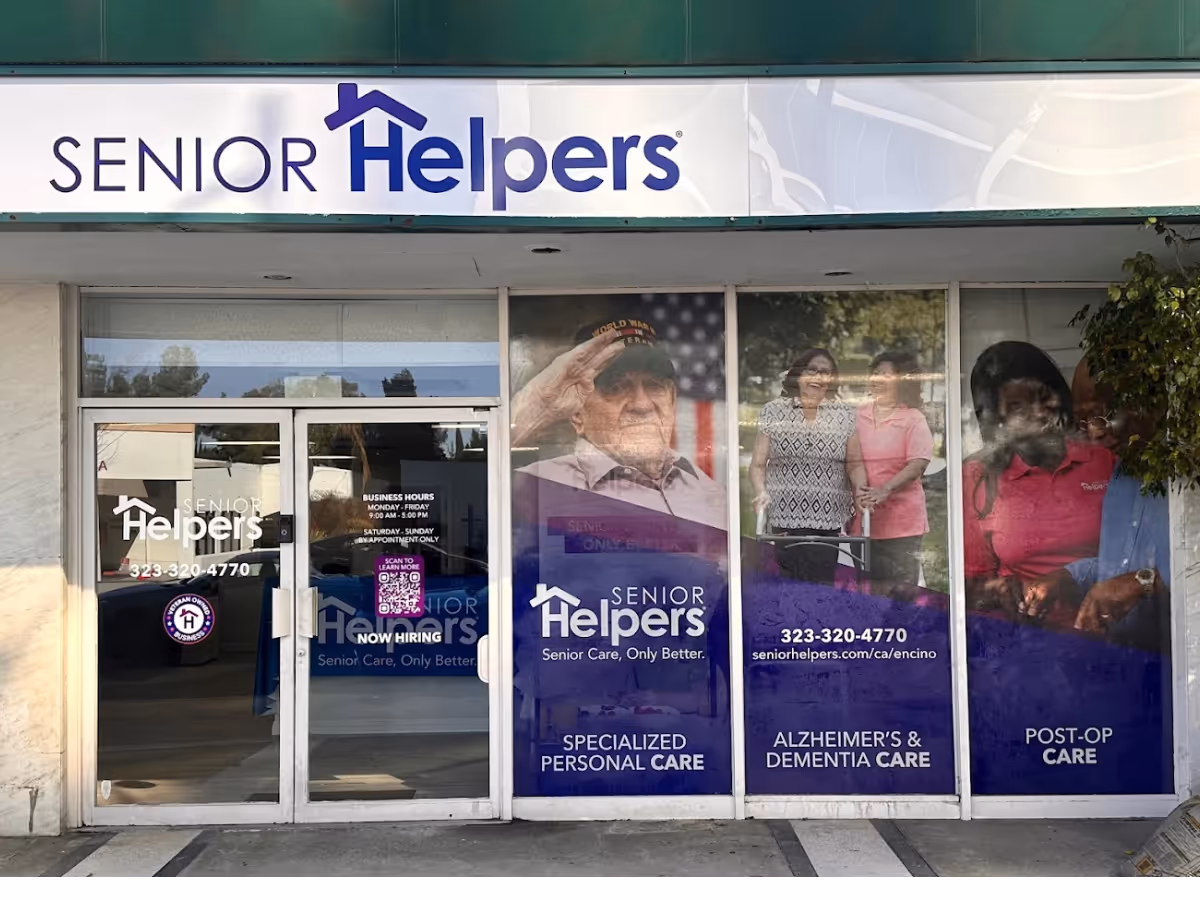 Front of Senior Helpers storefront with large windows displaying care posters.