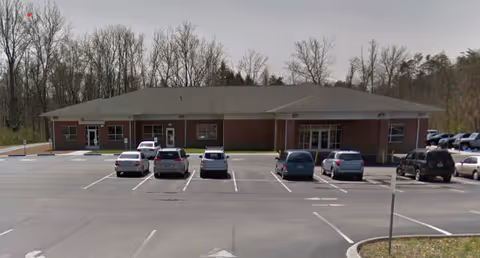 Exterior view of a single-story brick building with a parking lot.