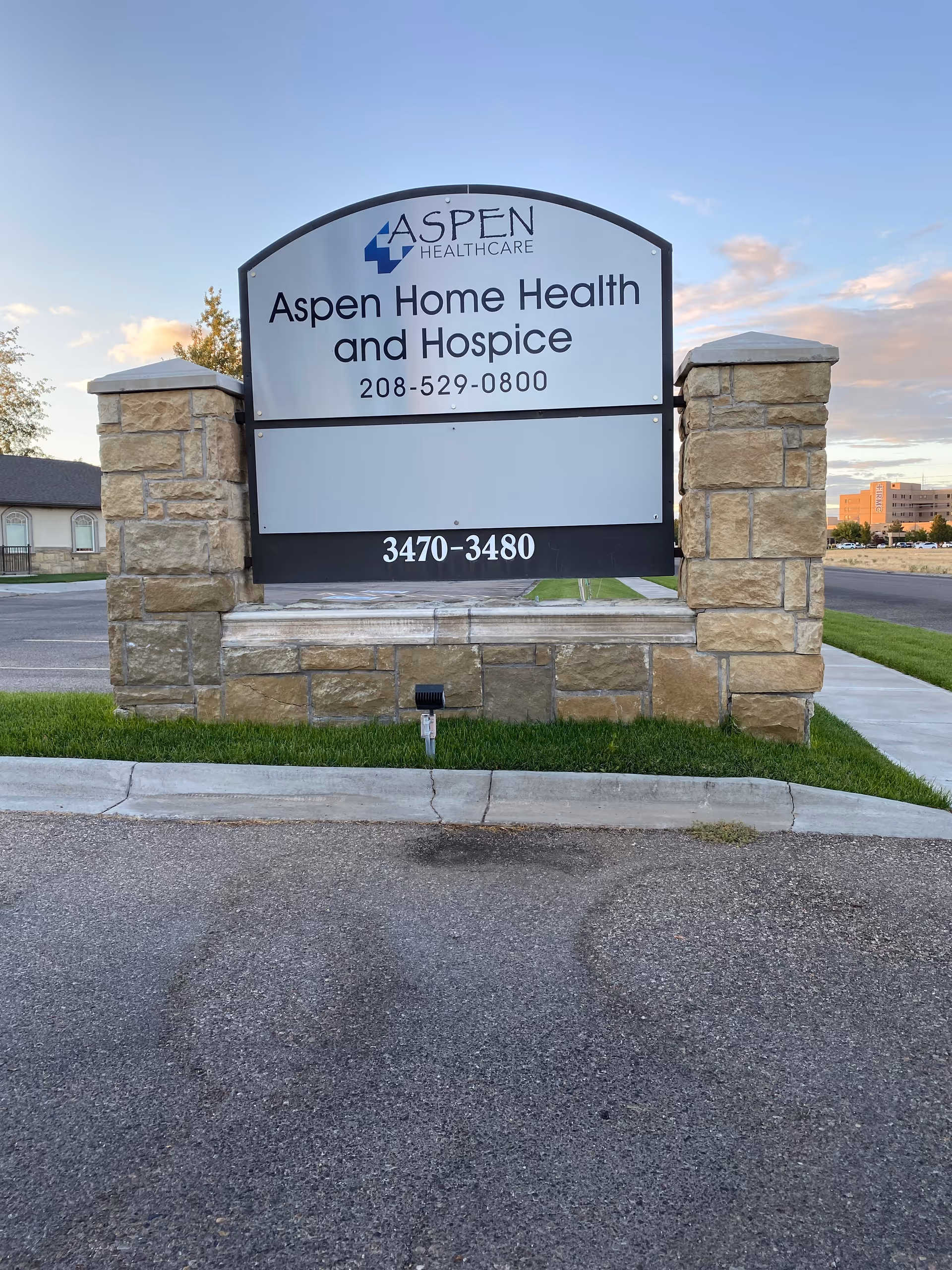 Stone-framed sign for Aspen Home Health and Hospice at the facility entrance