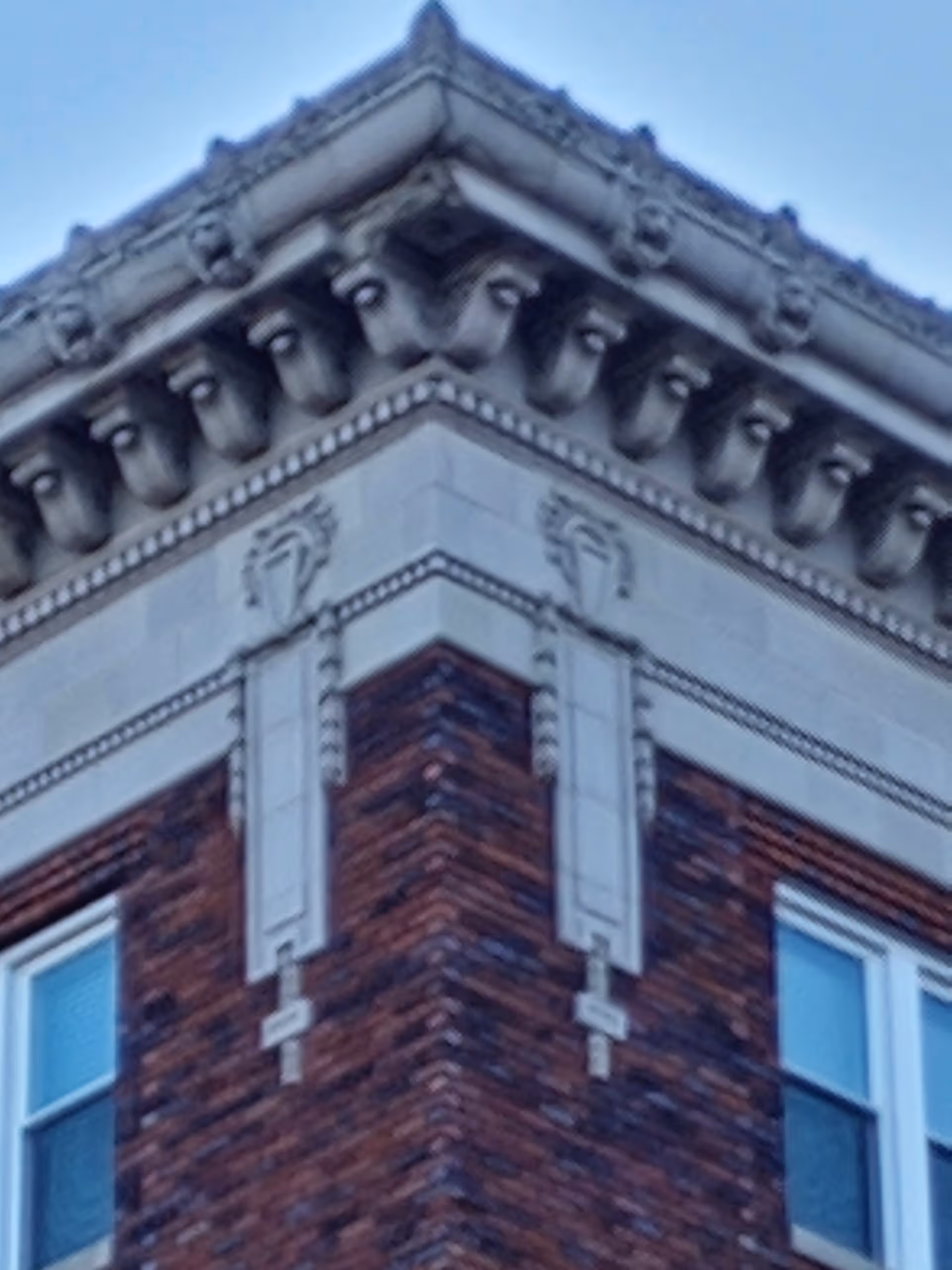 Corner view of a brick building with decorative stone trim and windows.