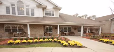 Exterior view of Brookdale Northville with a covered porch and flowerbeds.