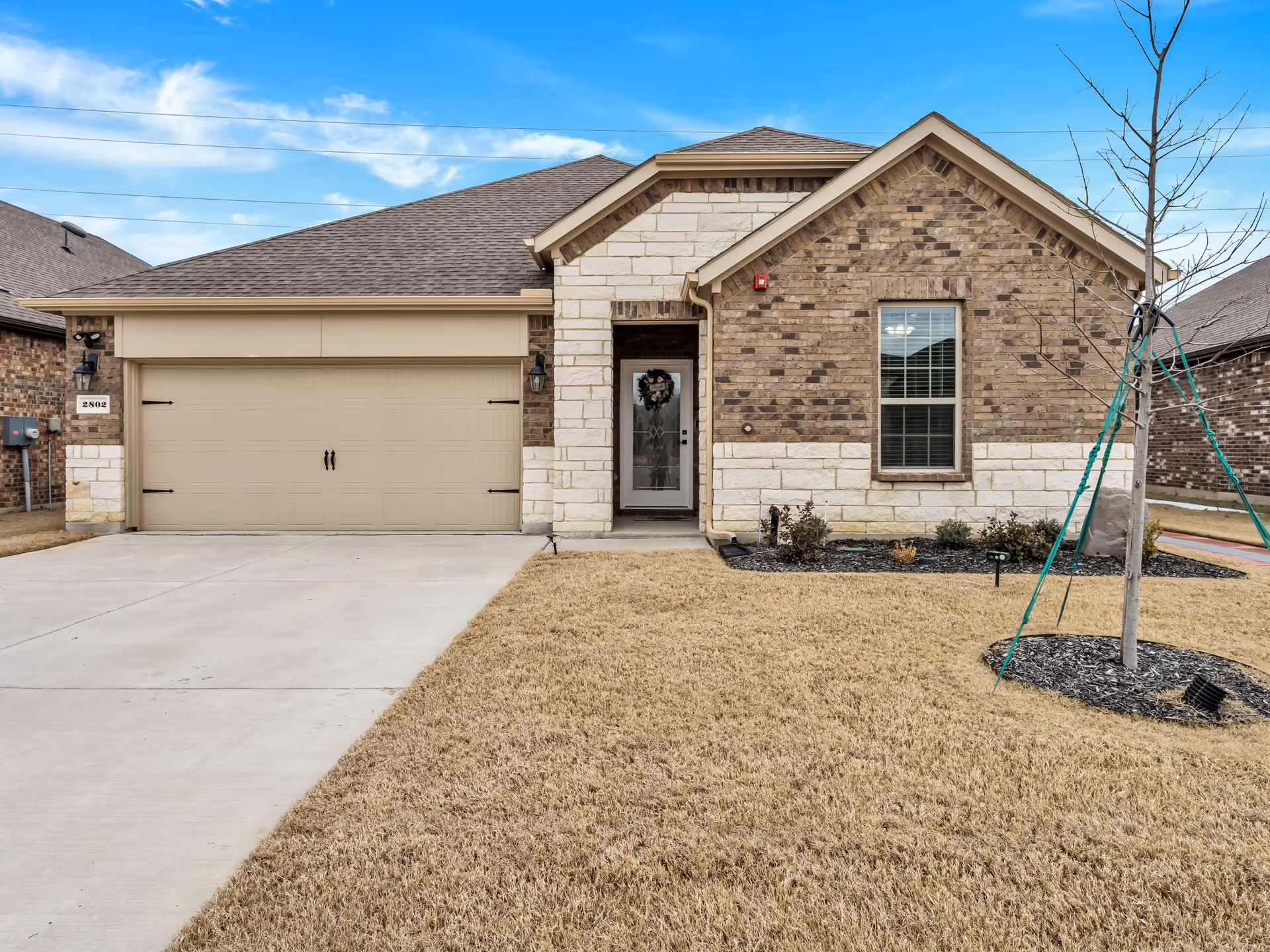 Front view of a Careessence Assisted Living facility with brick exterior and a two-car garage.