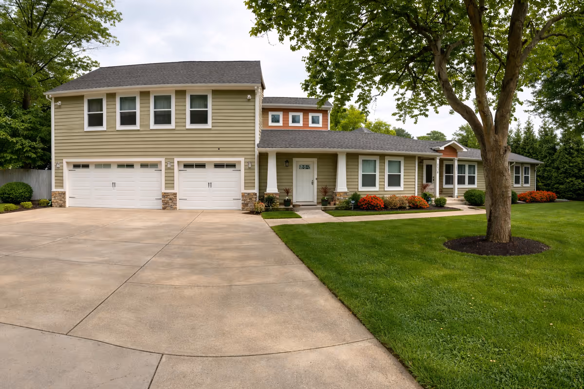 A modern senior living facility with brick accents, multiple garage doors, and a landscaped lawn.