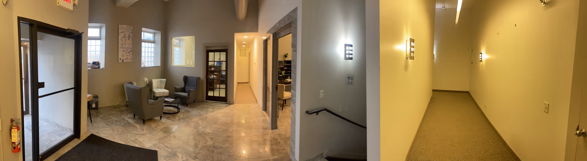 Lobby-style interior with seating area and a long hallway.