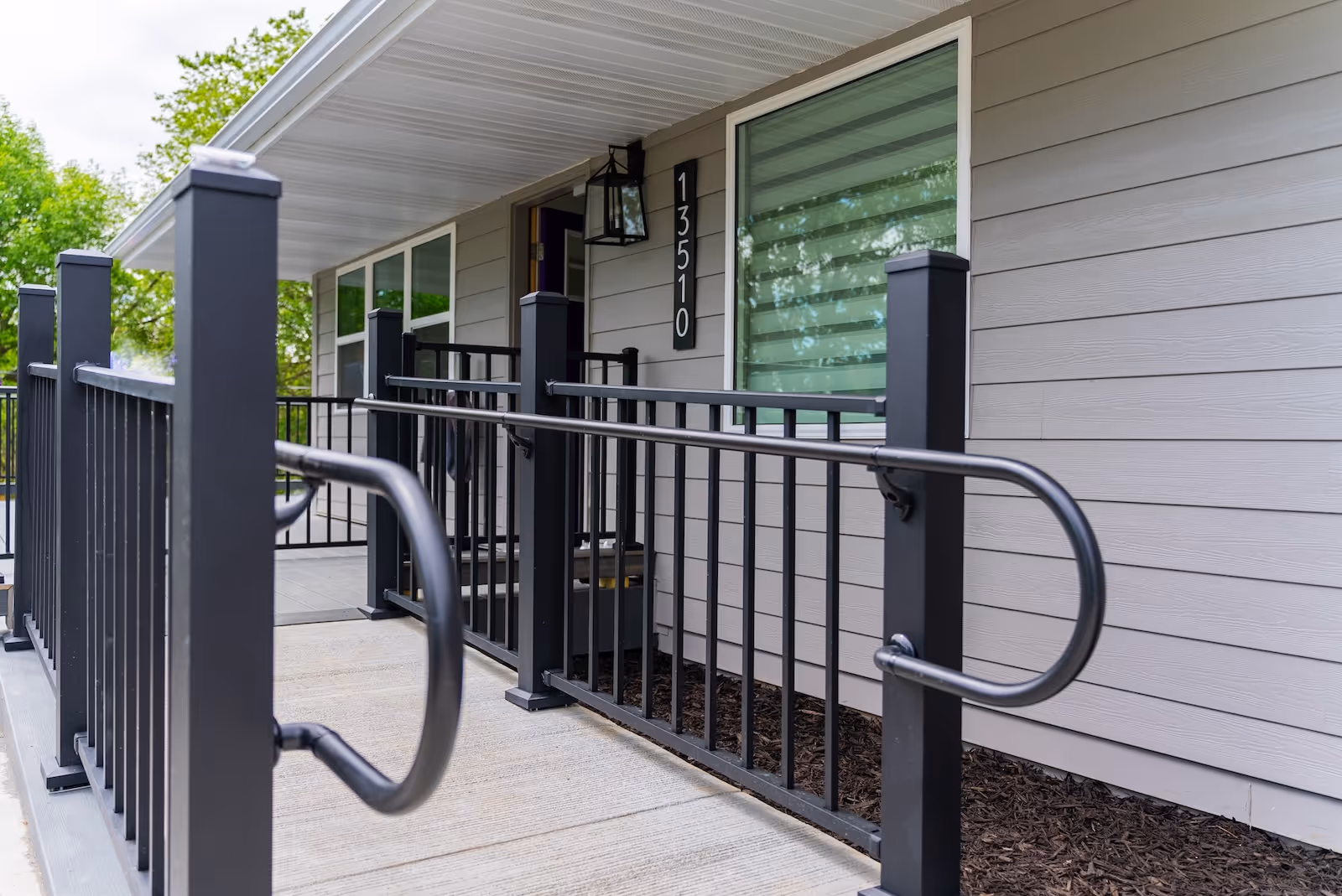 Exterior view of a senior living facility entrance with a wheelchair ramp.
