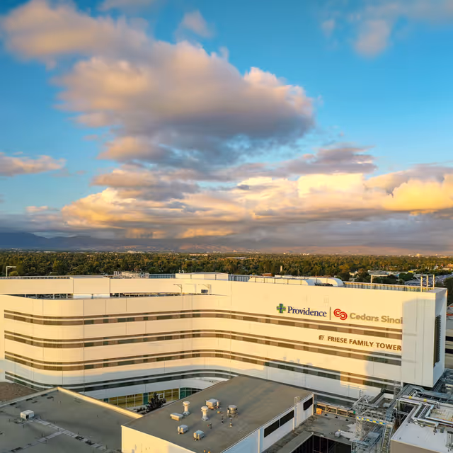 Aerial view of a curved white Providence facility with signage and a blue sky.