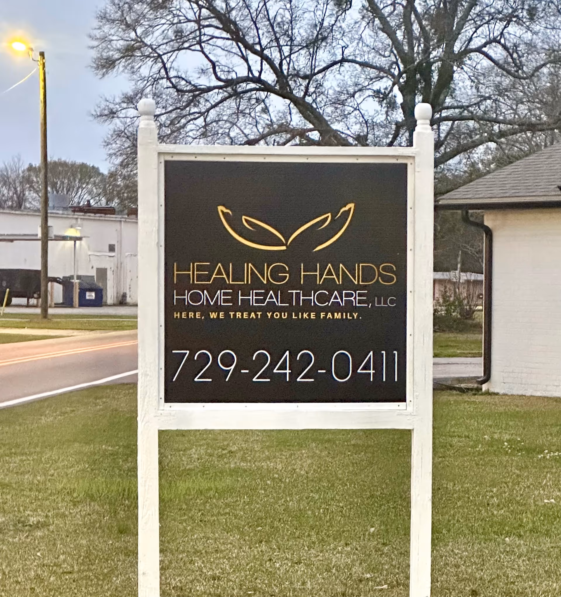 Sign for Healing Hands Home Healthcare LLC on a grassy roadside lawn.