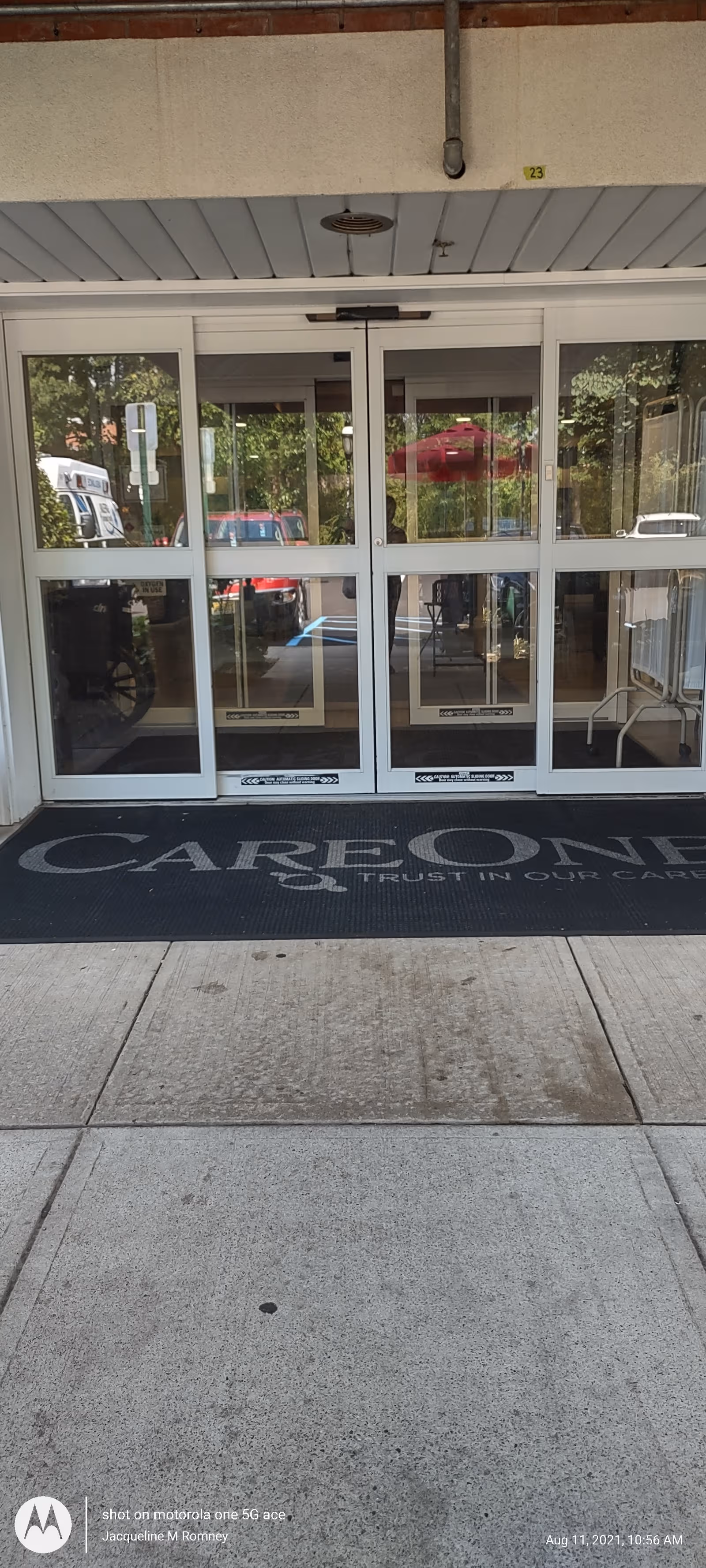 Glass entrance doors at CareOne at Ridgewood Avenue with a dark mat outside