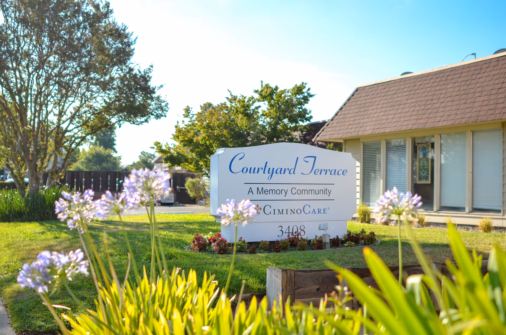 Front exterior of Courtyard Terrace senior living facility with sign and landscaping.