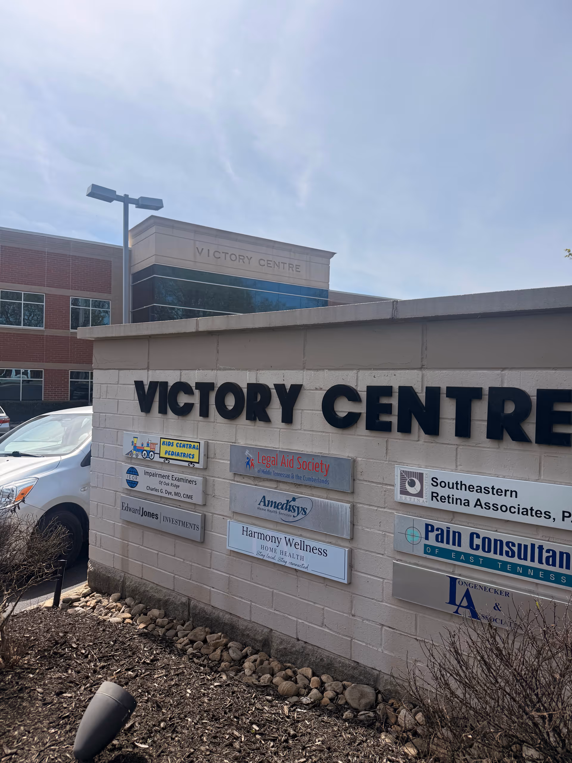 Exterior view of building with Victory Centre sign and tenant signs, Harmony Wellness Home Health.