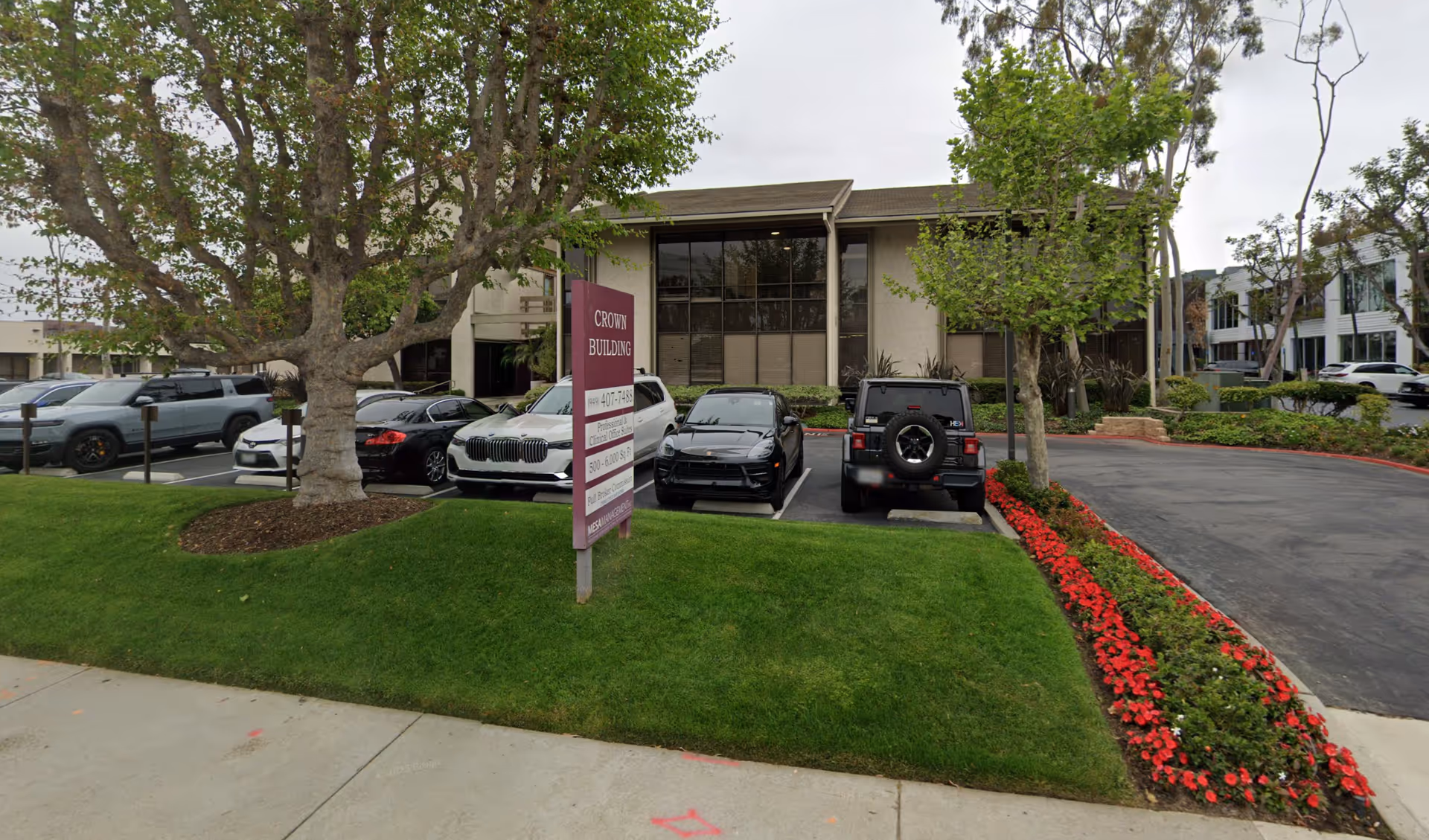 Front view of Newport Home Care building with cars in the parking lot.