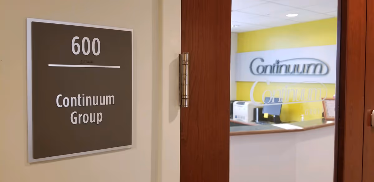 Interior doorway to a reception area with yellow wall and Continuum logo
