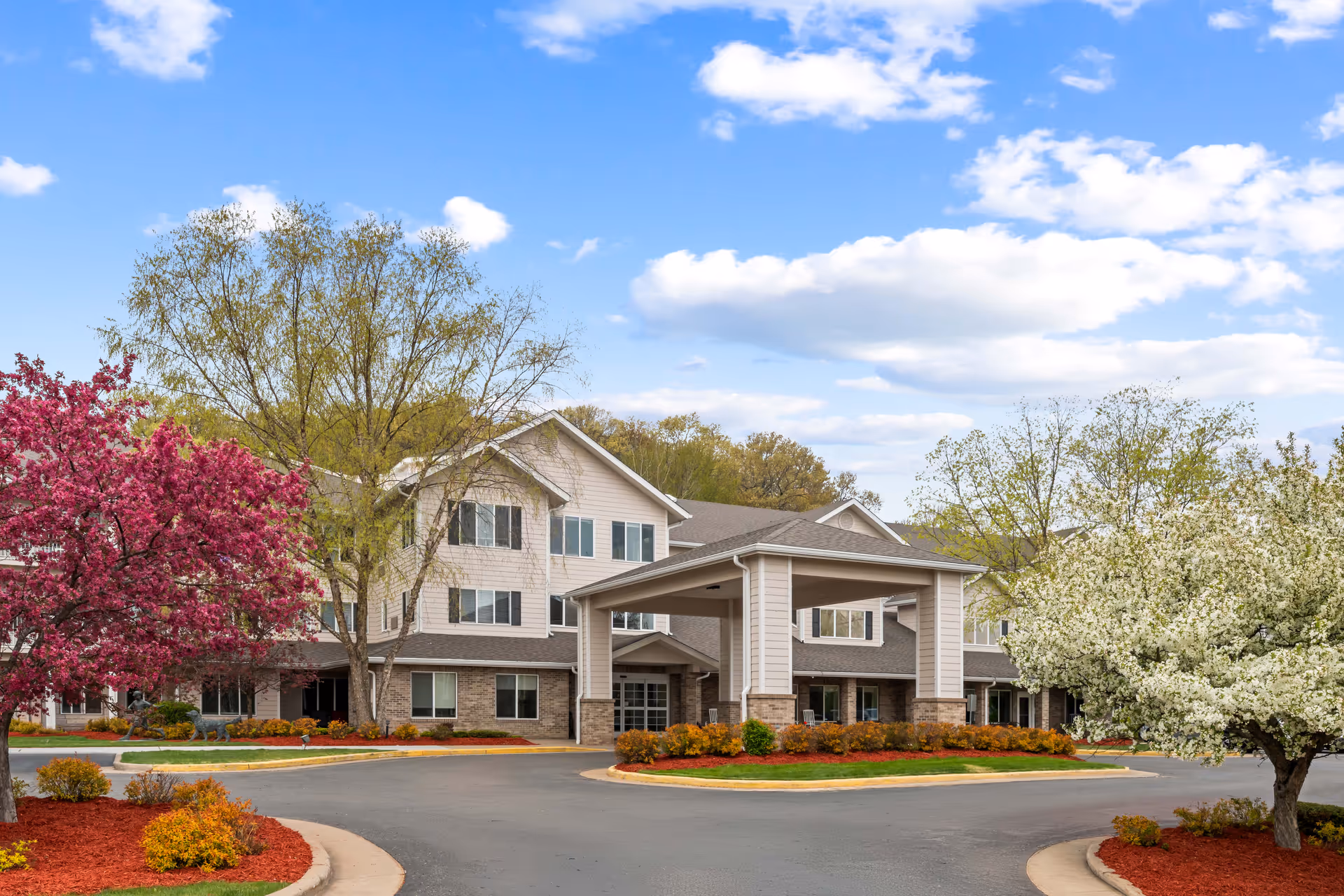A multi-story senior living facility with a covered entrance and landscaped grounds.