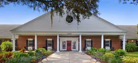 Front view of Brookdale Colonial Park exterior with brick facade, benches, and landscaping.