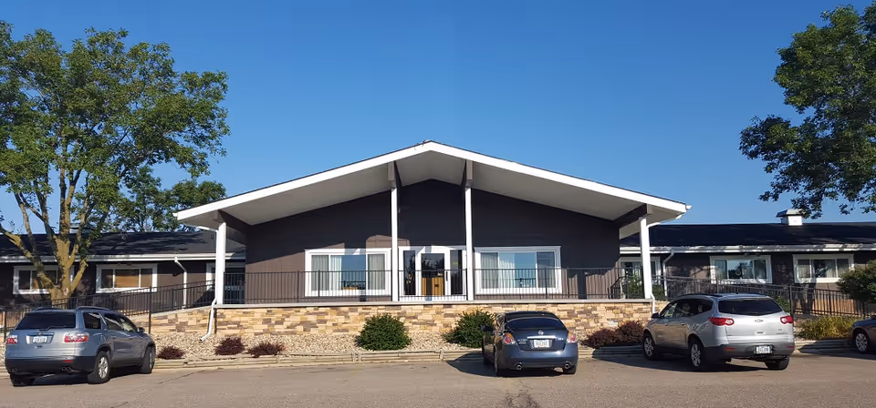 Front view of Casa De Paz Health Care Center with a covered entrance and parked cars.