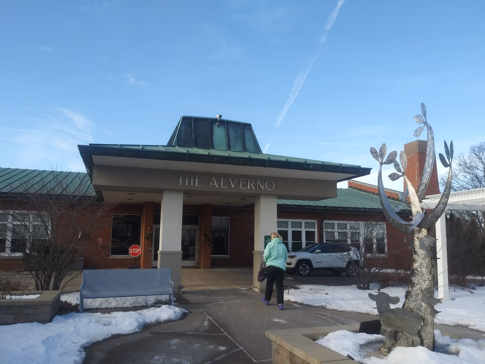 Front entrance of The Alverno Senior Care Community with a person walking in.